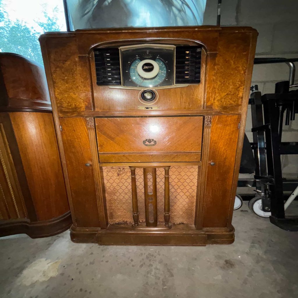 Full-size vintage wooden console radio with ornate cabinet, circular tuning dial, and classic radio speaker panel