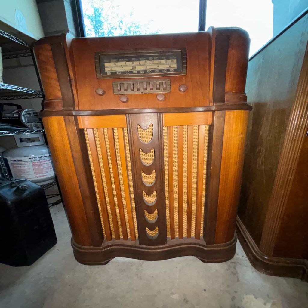 Collectible vintage radio console with wooden cabinet, push-button tuner, and decorative vertical speaker grille